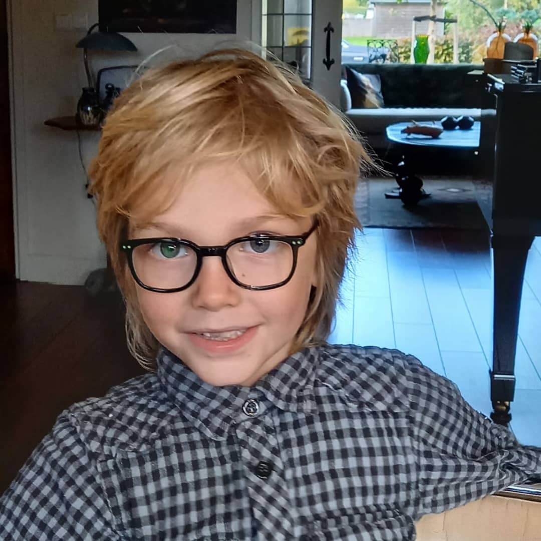 Jong kind met zwarte bril, trots