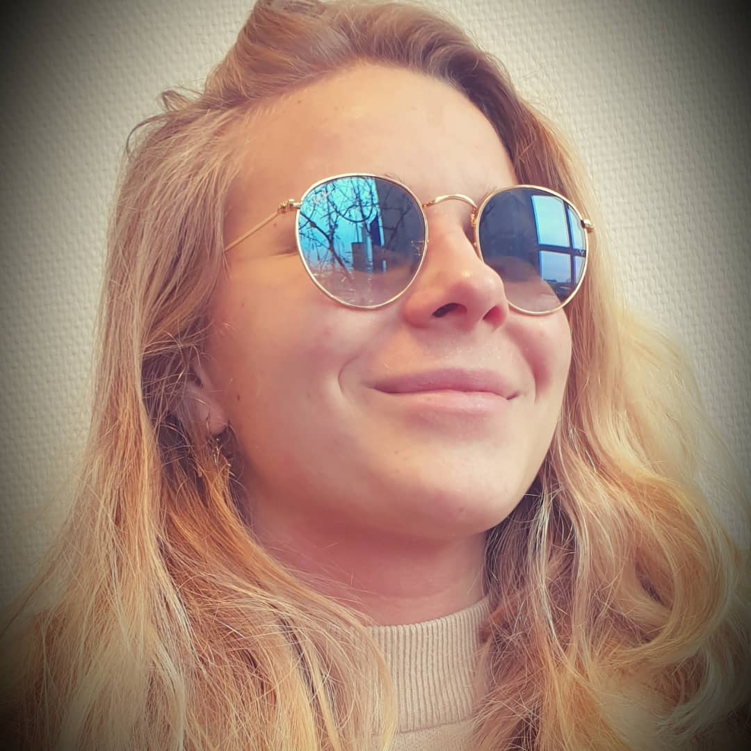 Dame met kleurrijke ronde bril, stralend portret