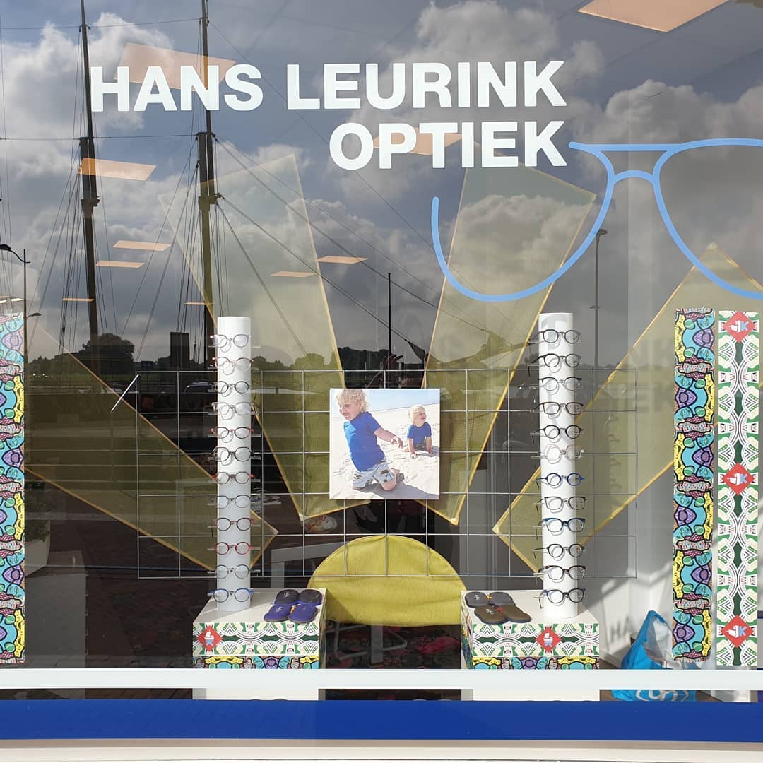 Etalage Hans Leurink Optiek met brillencollectie en Kampen skyline